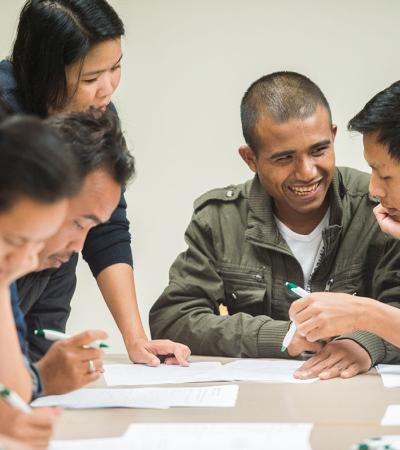 Experts from ASIA Inc. teach financial literacy to a Nepali-speaking man.