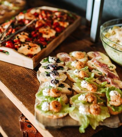 close up of trays of finger foods arranged on wooden surface