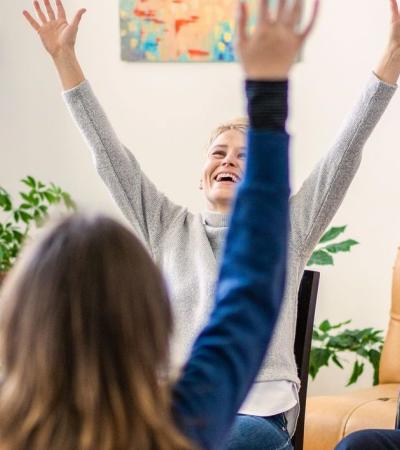 a fun time for support group sitting in a circle with arms thrown up in the air