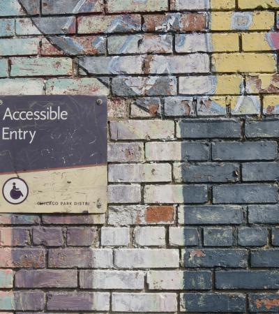 Photograph of a colorful brick wall with an Accessible Entry sign