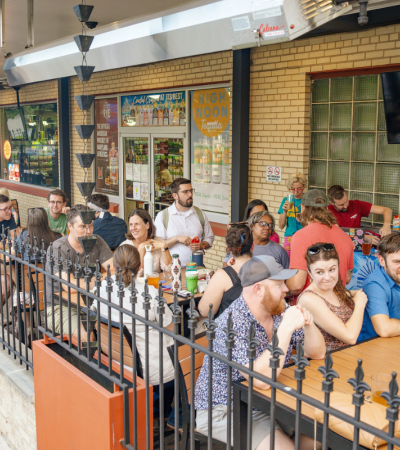 Photograph of people sitting at tables outside of a brewery