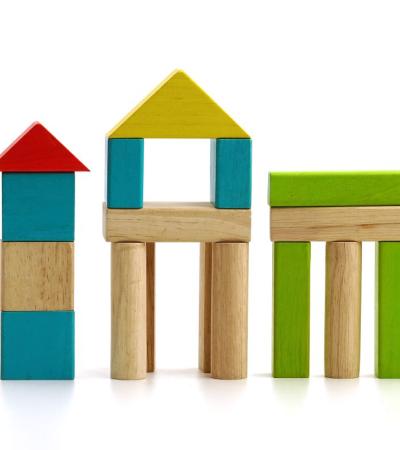 Photograph of wooden building blocks shaped as buildings.