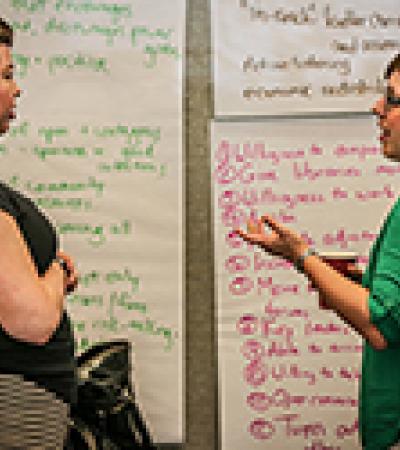 Librarians talking in front of a wall full of notes