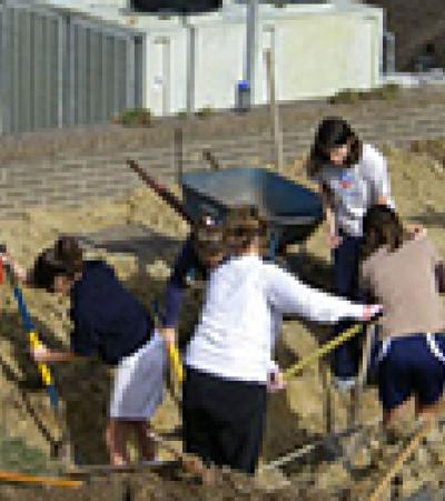 Students work on creating an organic vegetable garden outside the library.