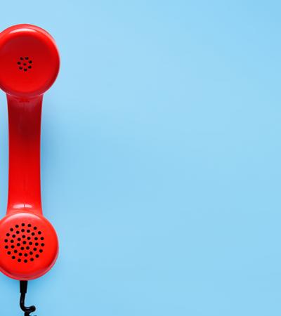 Photo of a red landline phone.