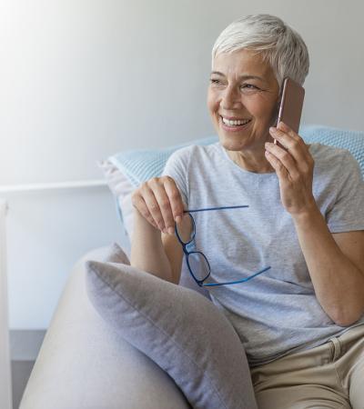 Woman sitting on the couch talking on the phone.