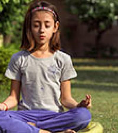 Young girl meditating outdoors