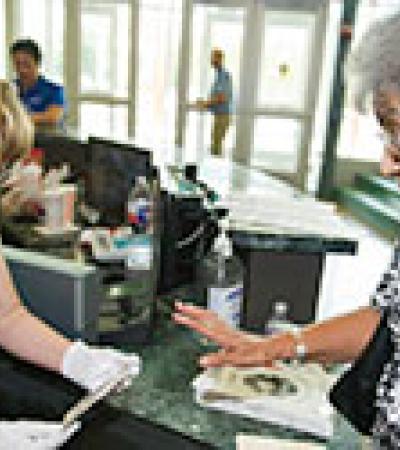 A woman consulting with an expert at the library on her family photographs