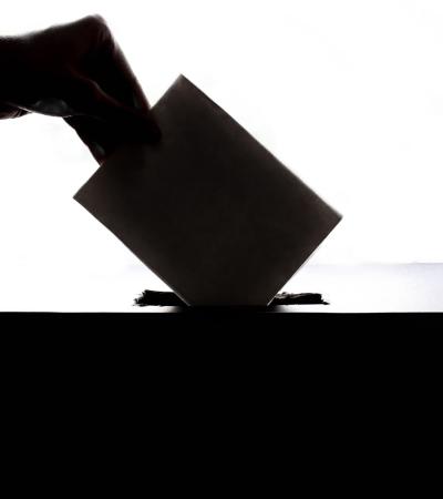 hand putting ballot in box