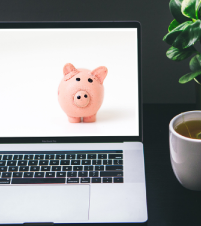 Photo of an open laptop with an image on a piggy bank on the screen