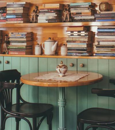 Table and chairs with book shelf behind it