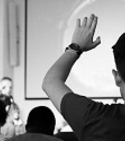 person raising hand during presentation