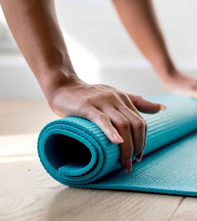 Woman rolling up yoga mat