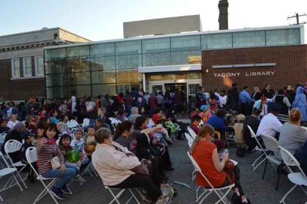 People seated in folding chairs watching the costume contest. 