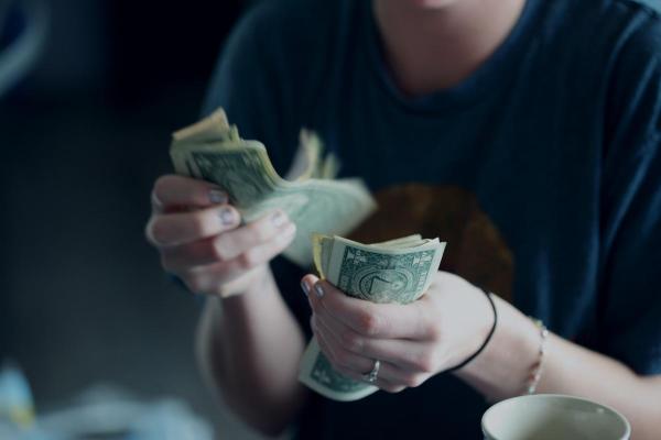 a person counting dollar bills