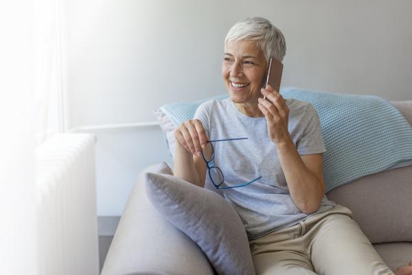 Woman sitting on the couch talking on the phone.