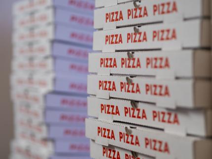 slant-angle view of stacks of pizza boxes