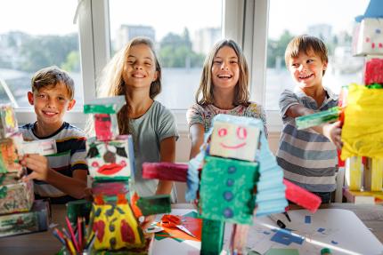 group of happy kids doing crafts at the library