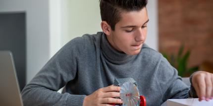 teenage boy concentrates on robotics project