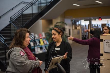 A librarian discusses the Civic Lab topic with a patron. 