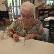 Person sitting filing out bingo card