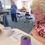 Person sitting filing out bingo card