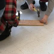 Hammering nails into a wooden board