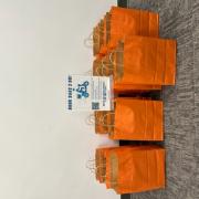 Photograph of bright orange Book Bags 2 Go