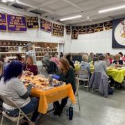 Tables of participants work on their charcuteries