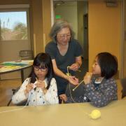 Two students getting help with their knitting