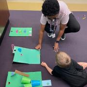 Photograph of child playing with mini mini golf