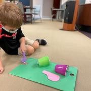 Photograph of child playing with mini mini golf