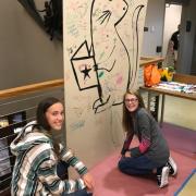 Teens drawing on the panel wall