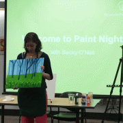 Becky O'Neil talks about her painting at the beginning of the event