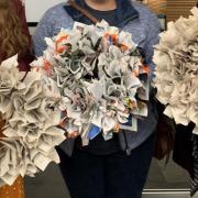 Patrons holding up completed book wreaths