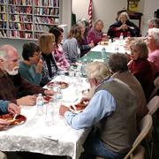 Cookbook Challenge participants gather around a table for the program's potluck. 