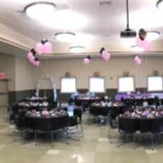 The entire decorated ballroom is on display with a lot of tables and balloons.