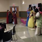 The women dressed as princesses are standing in front of the decorated stage.