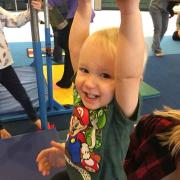 Child hanging from a beam