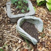 Completed hypertufa pots in a garden