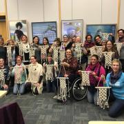 Participants holding up their finished wall hangings. 