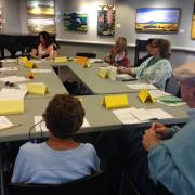 The class listens to the instructor while seated.