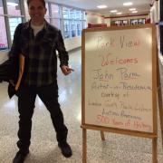 Writer John Parra in front of event signboard