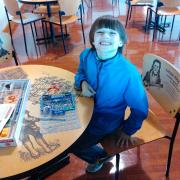 Boy smiling at a work station 