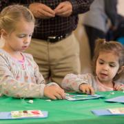 Girls making a craft at a Light Up the Holidays program