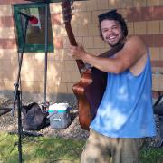 Musician playing guitar at the Farmers Market