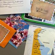 Photograph of pen pal program marketing in New Zealand: "Dear Delaware" postcard examples on a board. 