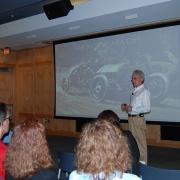 Clifford Zink stands in front of a seated crowd of people while giving a presentation.