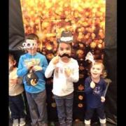 Three children in the photobooth with props