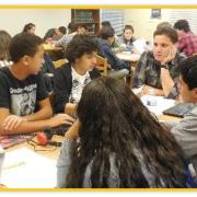 Students and John Parra talking at a table